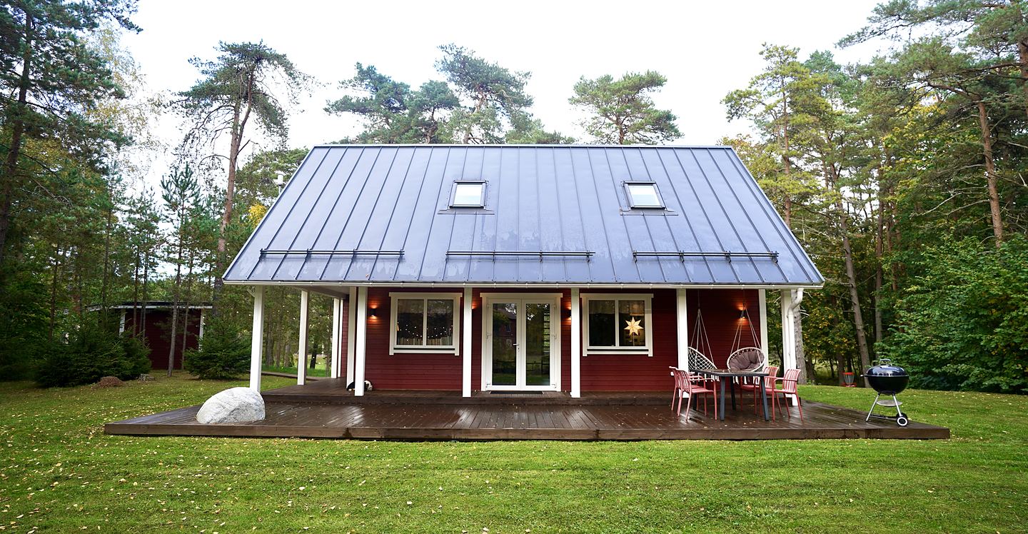 Huvudhuset framifrån med terrass och utemöbler